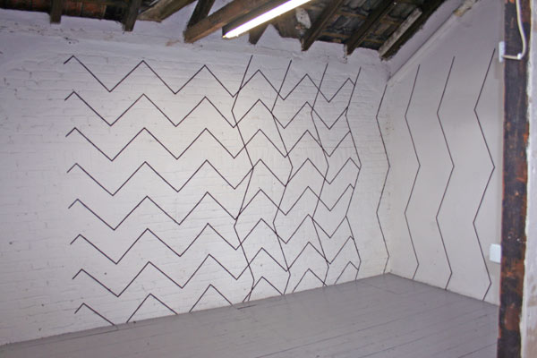 Wand mit schwarzen Linien im Zick-Zack-Muster aus Klebefolie